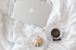 coffee cup macbook laptop working breakfast bed bedroom stock photo