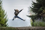 woman jump backpack jumping leap adventure blonde hair stock photo