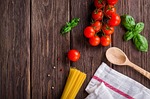 spaghetti tomatoes basil wooden spoon rustic table flat stock photo