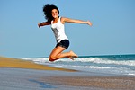 woman beach jump happy female smiling nature smile stock photo