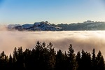 mountains fog trees landscape sky clouds nature high stock photo