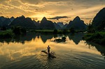 fisherman fishing sunset calm lake nature stock photo