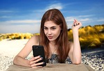 girl holiday plans travels smartphone telephone internet beach stock photo
