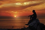 manipulation sunset sunrise boy thinking rock silhouette nature stock photo
