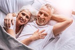senior couple bed happy stock photo