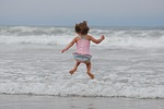girl beach jump ocean waves jumping bathing suit stock photo
