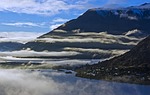 mountains mist water lake mountainous clouds landscape nature stock photo