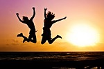 new year background sunset beach silhouettes jump jumping stock photo