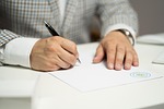 man sign paper write document contract signing agreement stock photo