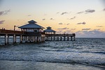 beach pier sunset sea ocean water calm waves stock photo