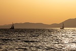 sunset sea boats ocean nature mountains evening atmosphere stock photo