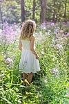 child girl wildflowers nature walking purple spring stock photo