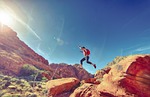 man jumping mountains rock formations jump joyful happy stock photo