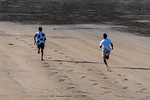 men run sprint competition sports beach nature fun stock photo